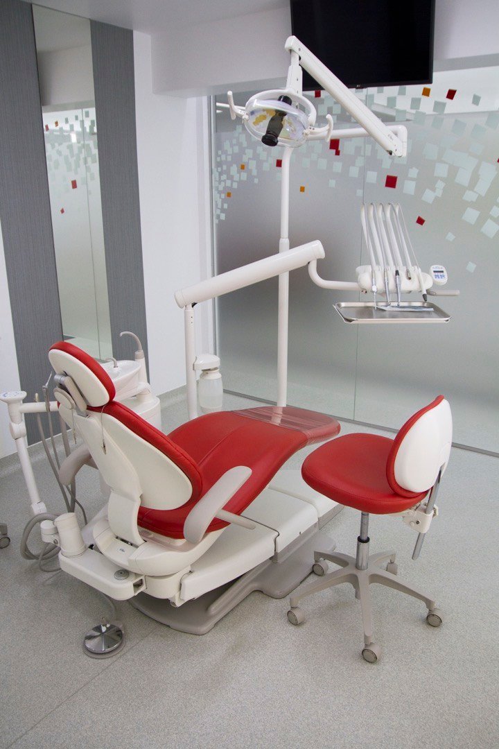 Dental treatment room with a chair, operating light and instrument tray